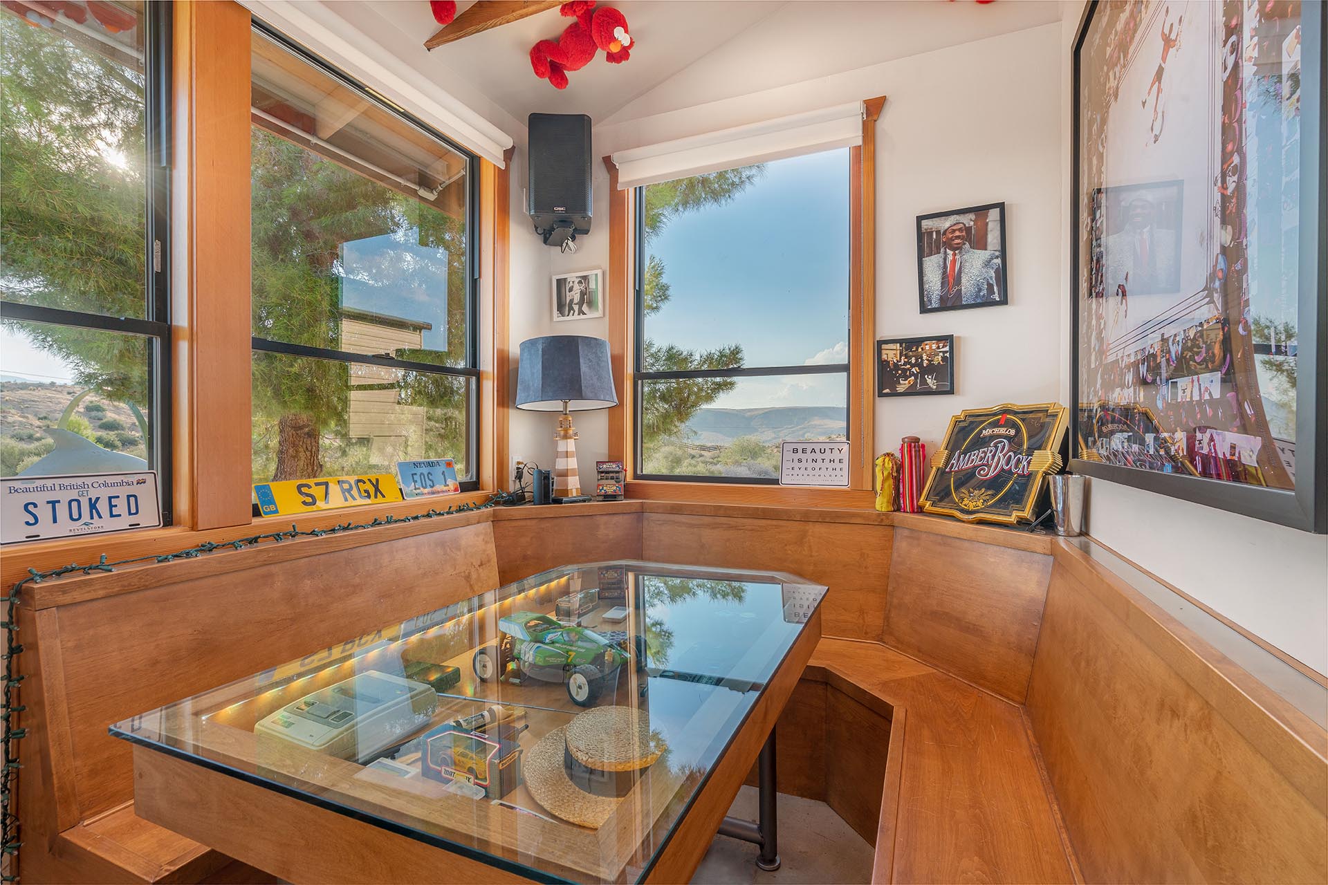 The booth at The Goat at ESCAPE — glass-top table over toy cars and memorabilia, license plates on the wall