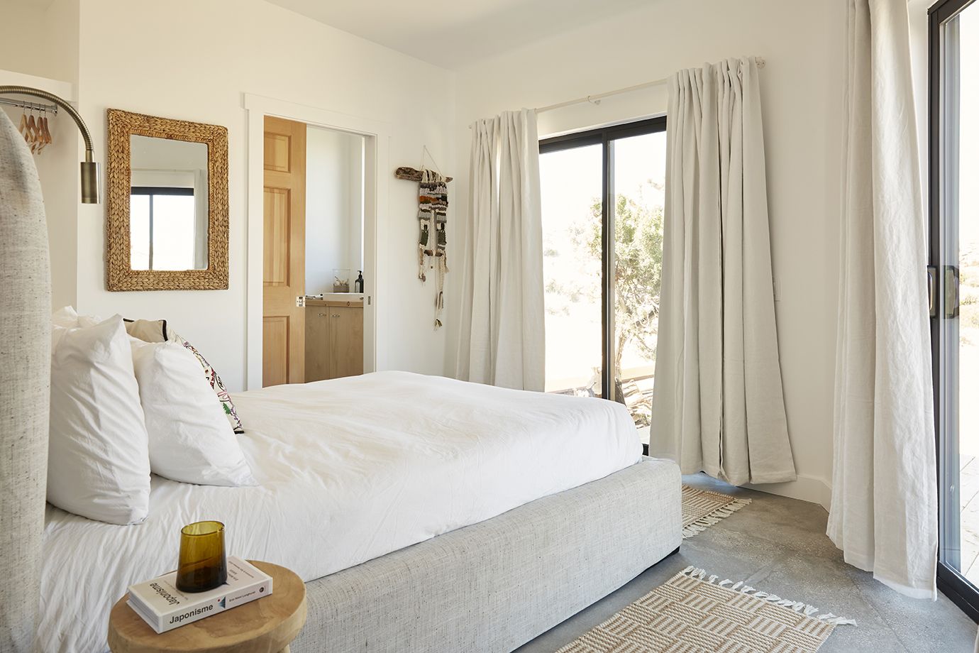 Lodge bedroom with linen drapes and desert door