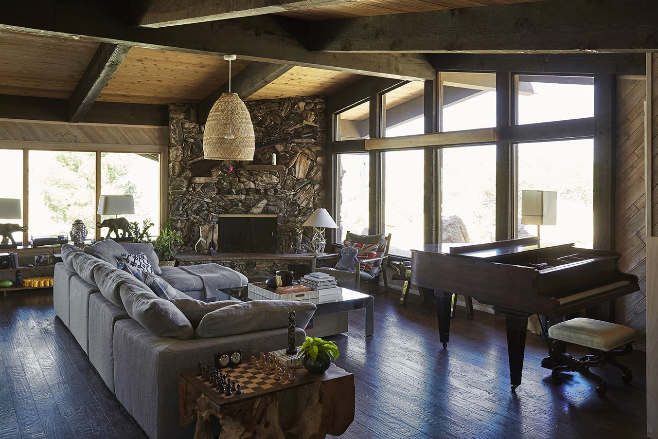 Main House living room with grand piano and stone fireplace