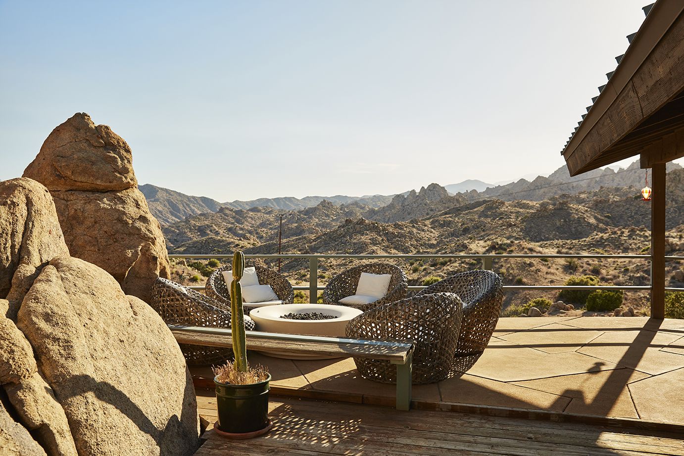 The firepit and terrace seating at the Main House — boulder, wicker chairs, mountain view