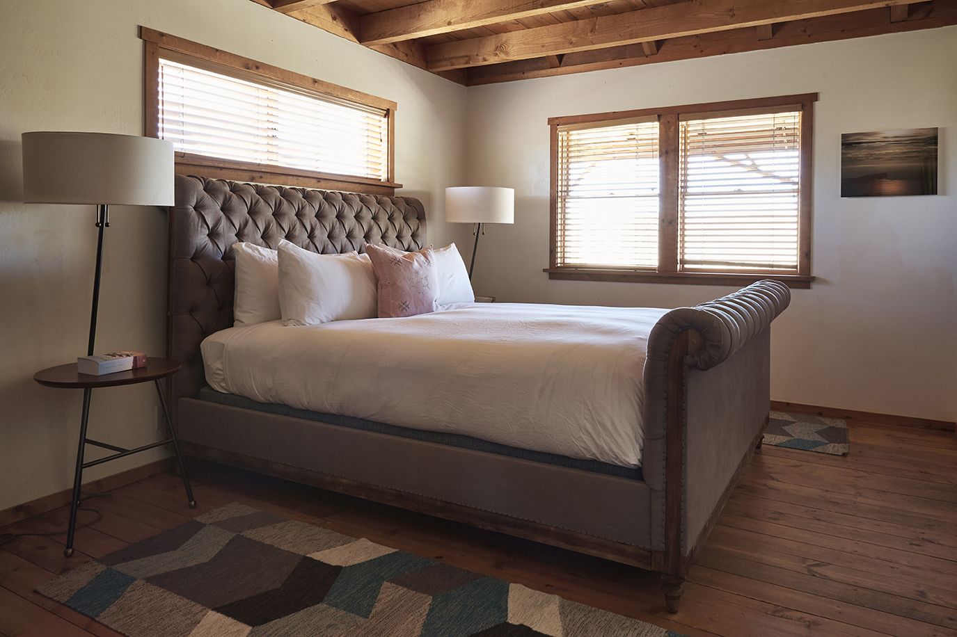 The Residence bedroom with sleigh bed and wood beams