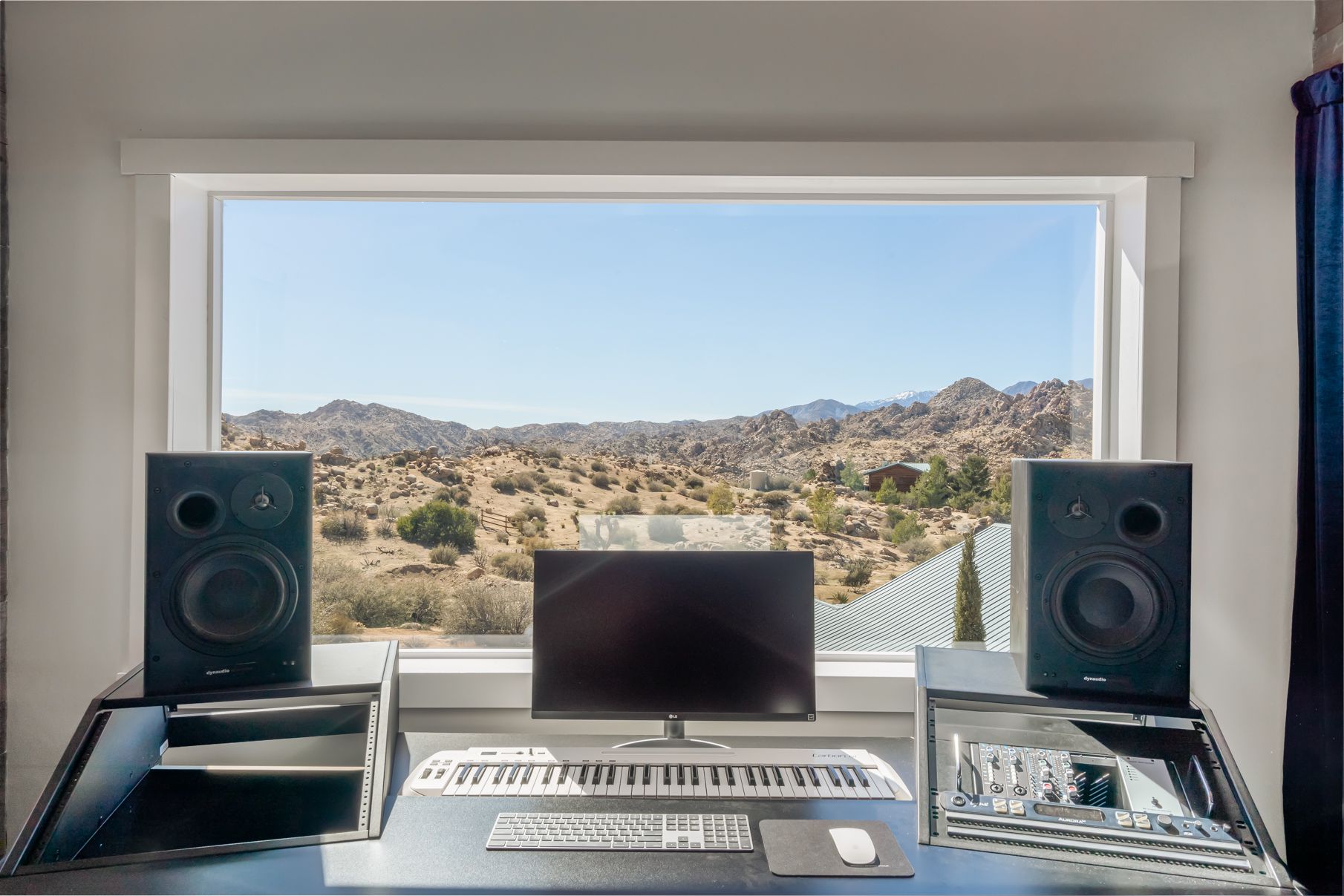 The Songwriting Suite at ESCAPE — desk and monitors with the big desert window